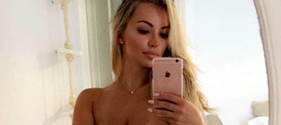 Lindsey Pelas taking a selfie topless in front of the mirror with her hair down