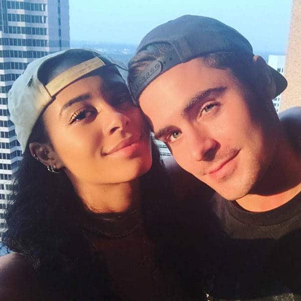 sami miro and zac efron with hats on backwards taking a selfie