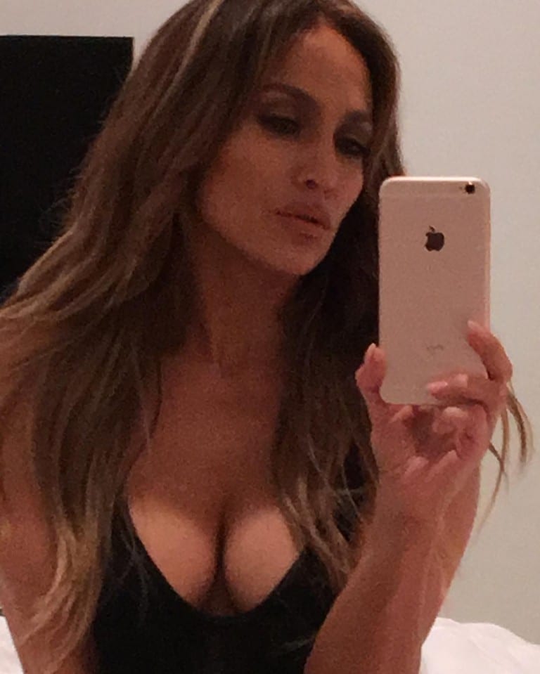 Jennifer Lopez taking a mirror selfie and showing off her busty cleavage