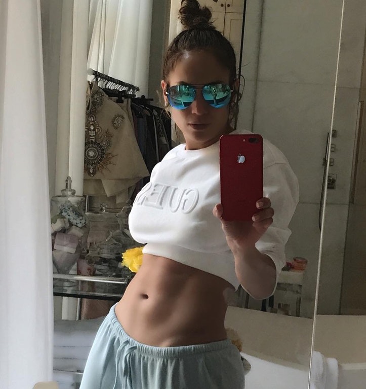 Jennifer Lopez taking a selfie and showing off her stomach